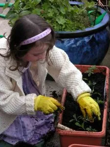 Child in garden Girl planting - ideas for family garden